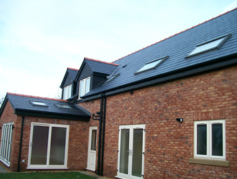 Brick rear elevation with dormers, roof lights and white sliding doors